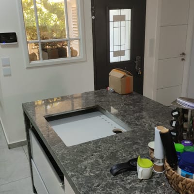 משטח שיש כהה במטבח מודרני עם כיור מובנה