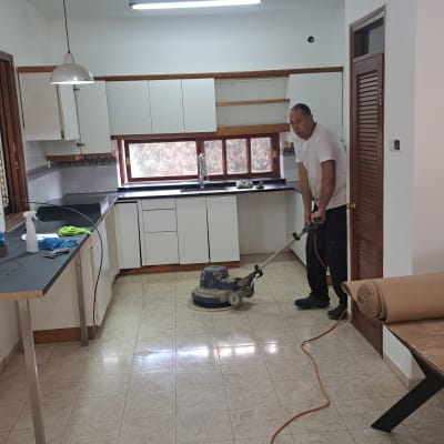 אדם מנקה רצפה במכונת פוליש במטבח
