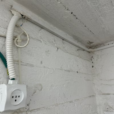 שקע חשמל עם חוטים חשופים וצינור פלסטיק