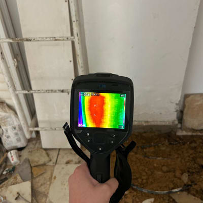 מד חום תרמי ביד על רקע רצפה שבורה