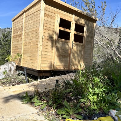 מחסן עץ עם דלתות, כלי עבודה צהוב על הקרקע