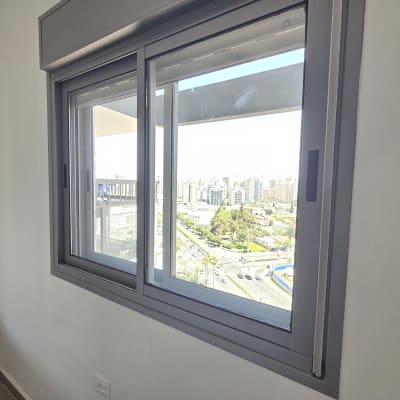 חלון אלומיניום עם נוף עירוני ברקע