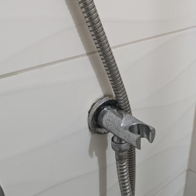 צינור מתכת מחובר לקיר בחדר אמבטיה