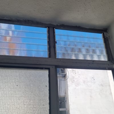 תריסים זכוכית עליונים בחלון עם מסגרת מתכת