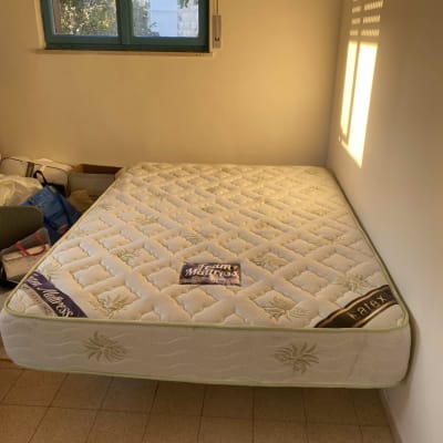 מזרן מונח על רצפה ליד חלון עם אור שמש