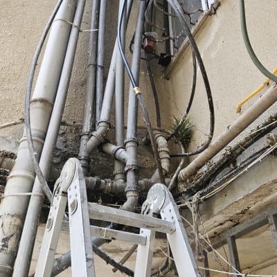סולם וצינורות חיצוניים על קיר בניין