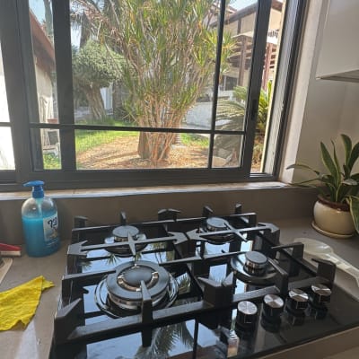 כיריים גז במטבח עם חלון פתוח ועצים בחוץ