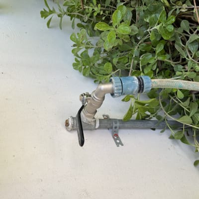 ברז מים עם צינור מחובר על קיר