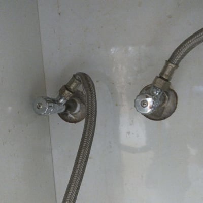 צינורות מתכת מחוברים לשסתומים בקיר