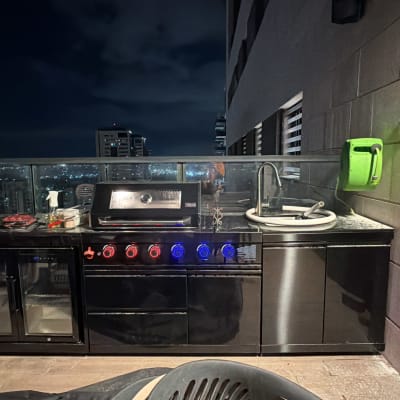 מטבח חוץ עם גריל וכיור על מרפסת בלילה