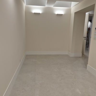 רצפת פרקט בחדר ריק עם תאורה עליונה