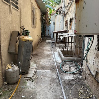 בלוני גז, צינורות וחוטי חשמל בחצר אחורית