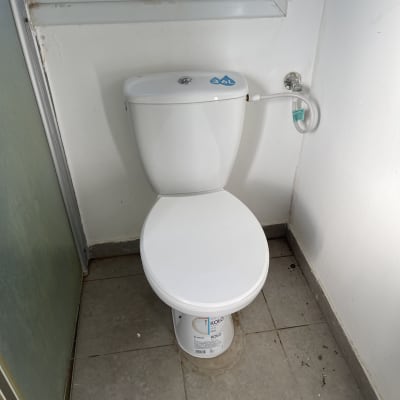 אסלה חדשה מותקנת בחדר אמבטיה עם רצפת אריחים.