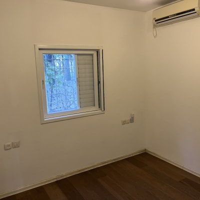 קיר צבוע בלבן עם חלון ומזגן