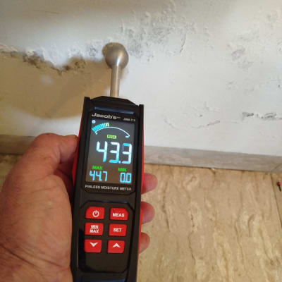 מד לחות דיגיטלי על קיר עם סימני רטיבות