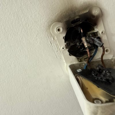תמונה של שקע חשמלי שרוף עם חוטים חשופים