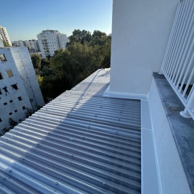 גג אלומיניום גלי מחובר לקיר בניין