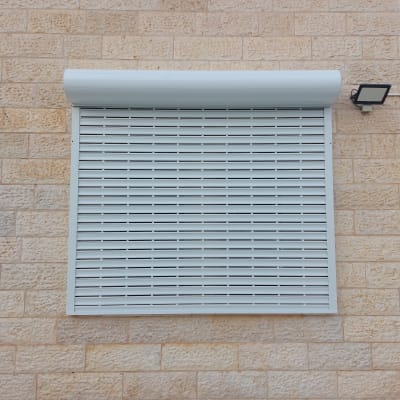 תריס אלומיניום סגור על קיר אבן חיצוני