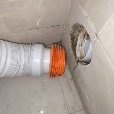 צינור מחובר לקיר עם חור בתהליך תיקון