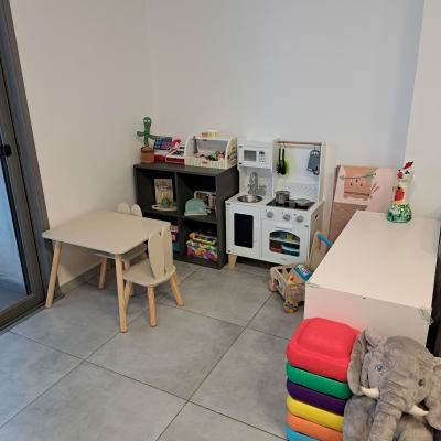 פינת משחקים לילדים עם מטבח צעצוע וכיסאות צבעוניים