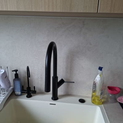 ברז שחור בכיור מטבח עם כלים וסבון כלים