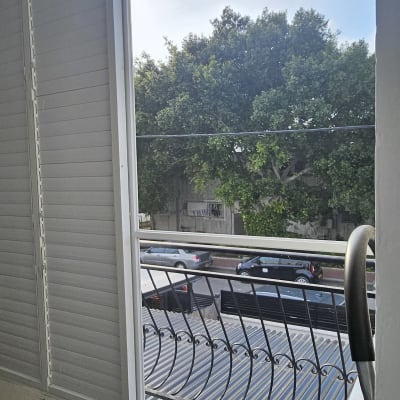 חלון אלומיניום עם תריסים ונוף חיצוני