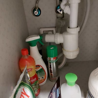 צנרת מתחת לכיור עם חומרי ניקוי