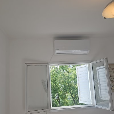 מזגן מותקן מעל חלון פתוח בחדר