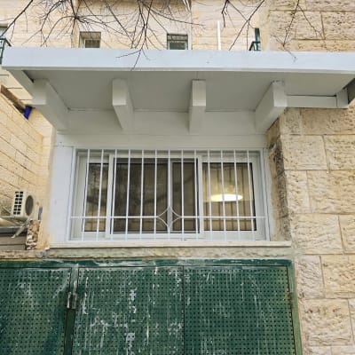 חלון עם סורגים ומסגרת מתכת ירוקה