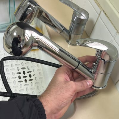 יד מחזיקה ברז נשלף בכיור מטבח