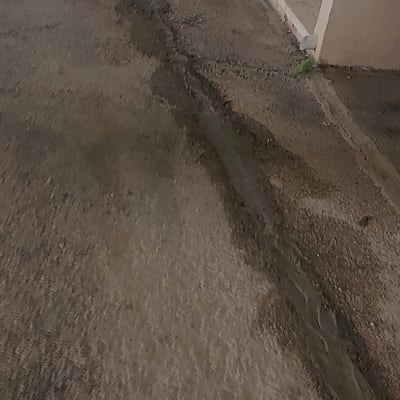 סדק ברצפה עם סימני רטיבות ליד צינור