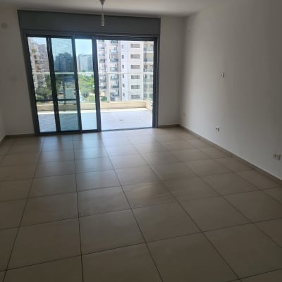 רצפה נקייה עם חלון גדול ודלתות זכוכית.