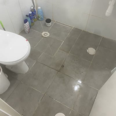 רצפת חדר אמבטיה עם ניקוז ומים על הרצפה