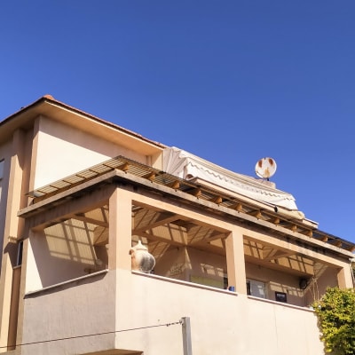 מרפסת עם גג עץ וצלחת לוויין על הגג