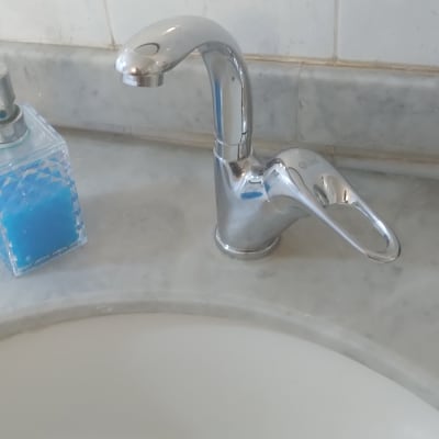 ברז כרום מעל כיור לבן עם סבון נוזלי