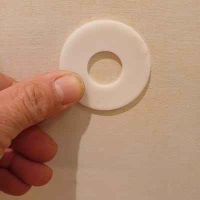 אדם מחזיק דיסקית פלסטיק לבנה עם חור