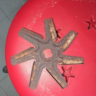 חלק מתכת חלוד בצורת כוכב על רקע אדום