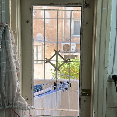 דלת זכוכית עם סורגים מתכתיים