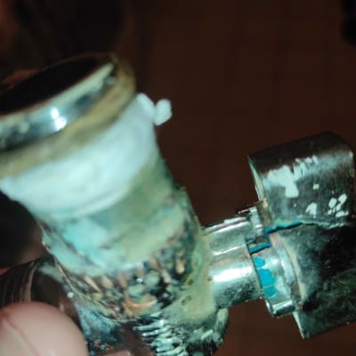 שסתום מתכת עם סימני חלודה ואיטום לבן