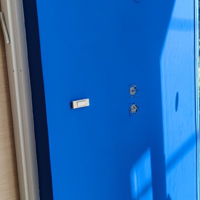 קיר צבוע בכחול עם חיווט חשמלי גלוי