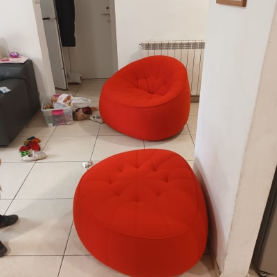 שני כורסאות אדומות בחדר עם צעצועים על הרצפה