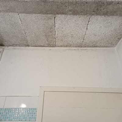 תקרה עם כתמי רטיבות וקיר לבן