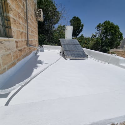 גג אטום בלבן עם צינורות ומערכת סולארית