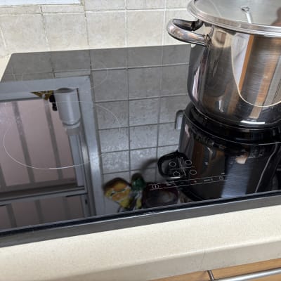 כיריים חשמליות עם סיר נירוסטה על משטח שיש