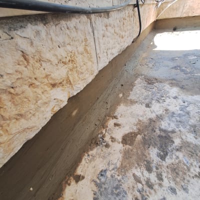 קיר אבן עם איטום חדש על רצפה רטובה