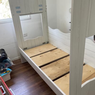 הרכבת מיטה בחדר עם כלים על הרצפה