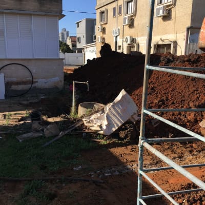 אתר בנייה עם ערימת אדמה, צינורות ומסגרת מתכת