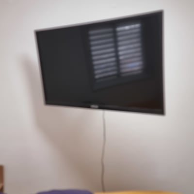 טלוויזיה תלויה על הקיר עם כבל חשמל