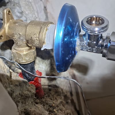 שסתום מתכת עם חיבורי צנרת בקיר