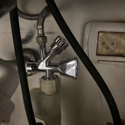 ברז מתכת עם צינורות מתחת לכיור